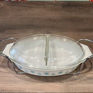 Vintage Pyrex oval divided casserole dish with lid and metal serving carrier.